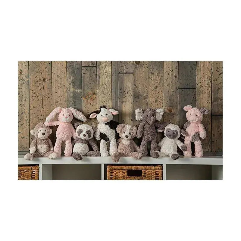 Mary Meyer Putty Nursery Character Blanket featuring a piglet among a collection of plush animal toys on a shelf.