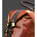 Brass Master Lock secured on a brown and orange bag, highlighting the zipper and strap details.