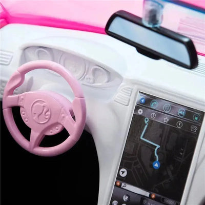 Barbie toy car interior featuring a pink steering wheel, dashboard with a touchscreen display, and navigation map.