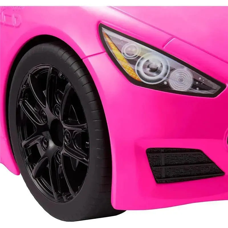 Pink Mattel Barbie toy car featuring a sporty design, black wheels, and detailed headlights.