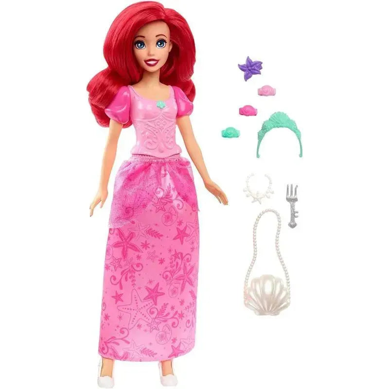 Disney Princess Ariel doll in a pink dress, with accessories including a tiara, seashell purse, and various themed decorations.