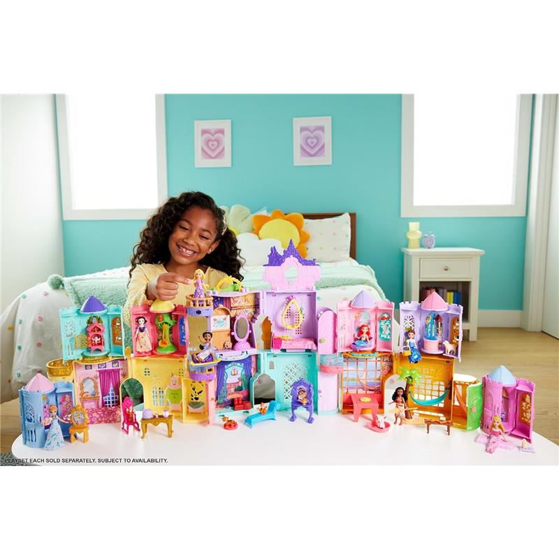 A young girl smiles while playing with the Mattel Disney Princess Stacking Castle featuring Rapunzel and other princess figures.