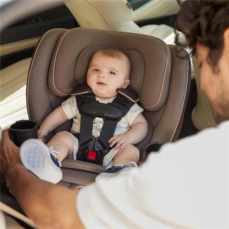 Maxi-Cosi Andi 360 Rotating All-in-One Convertible Car Seat in Escargot, featuring a baby seated securely with a caregiver present.
