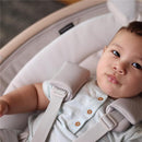 Infant resting in the Maxi-Cosi Cassia Smart Baby Swing, wearing a light blue shirt with buttons, secured in a soft, cushioned seat.