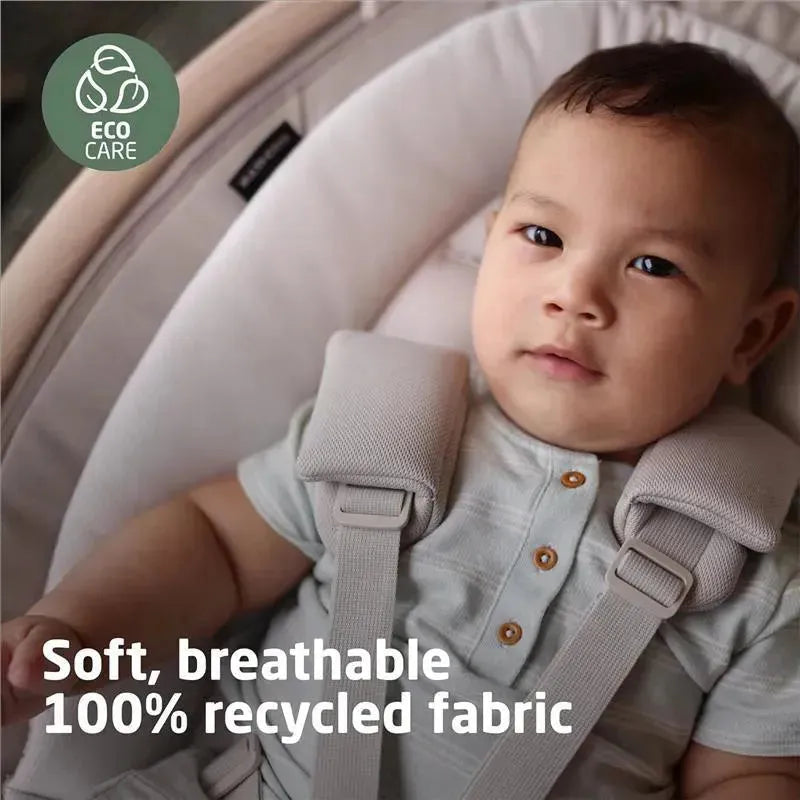 Maxi-Cosi Cassia Swing in Classic Oat with a baby wearing a gray shirt, showcasing soft, breathable, 100% recycled fabric.