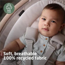 Maxi-Cosi Cassia Swing in Classic Oat with a baby wearing a gray shirt, showcasing soft, breathable, 100% recycled fabric.