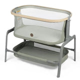 Maxi-Cosi Iora Bedside Bassinet in Classic Green, featuring mesh sides and a removable storage basket underneath.
