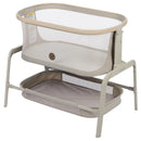Maxi-Cosi Iora Bedside Bassinet in Classic Oat, featuring a mesh sides, cream fabric, and a lower storage basket.