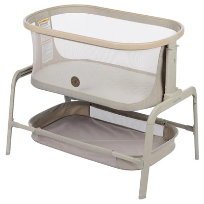 Maxi-Cosi Iora Bedside Bassinet in Classic Oat, featuring a mesh sides, cream fabric, and a lower storage basket.