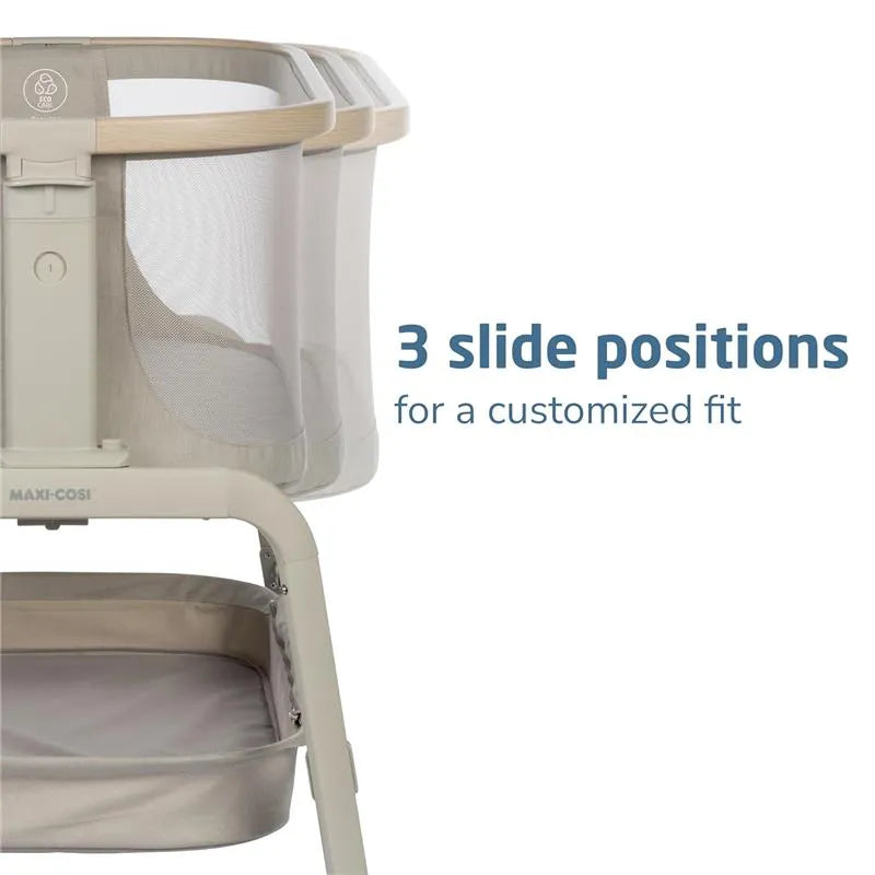 Maxi-Cosi Iora Bedside Bassinet in Classic Oat featuring three slide positions for customizable fit and a lower storage area.