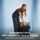 A woman is folding the Maxi-Cosi Oxford Cabin Lightweight Travel Stroller, showcasing its ultra-compact design for travel.