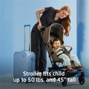 Lightweight Maxi-Cosi Oxford Cabin Stroller in Sea Shadow; woman adjusts stroller with toddler inside and a suitcase nearby.