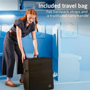 A woman in a striped outfit is lifting a black travel bag with backpack straps and a carry handle, highlighting its portability.