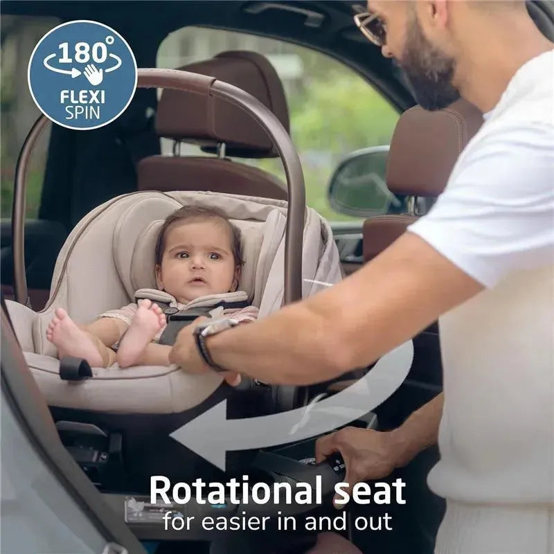 Maxi-Cosi Peri 180 Rotating Infant Car Seat in Desert Wonder with a child being secured, showcasing the 180° rotation feature.