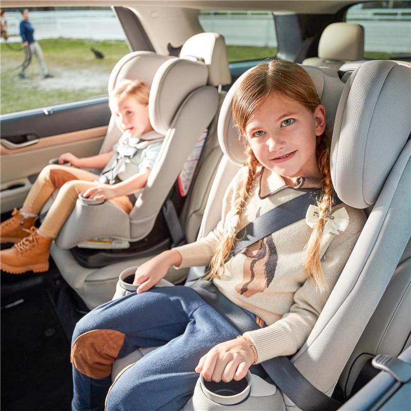 Maxi-Cosi Pria All-in-One Convertible Car Seat in Blackened Pearl, with two children seated in the backseat of an SUV.