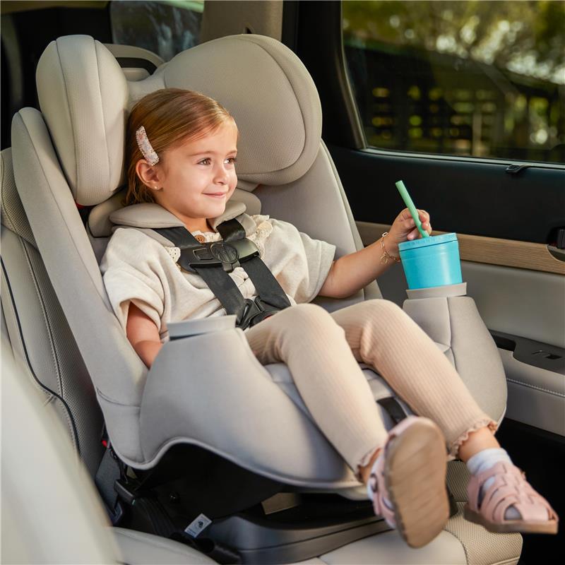 Maxi-Cosi Pria All-in-One Convertible Car Seat in SeaDrift, featuring a smiling child holding a drink in a vehicle.