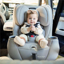 Baby in a Maxi-Cosi Pria All-in-One Convertible Car Seat, Seascape, inside a vehicle, smiling with hands clasped.