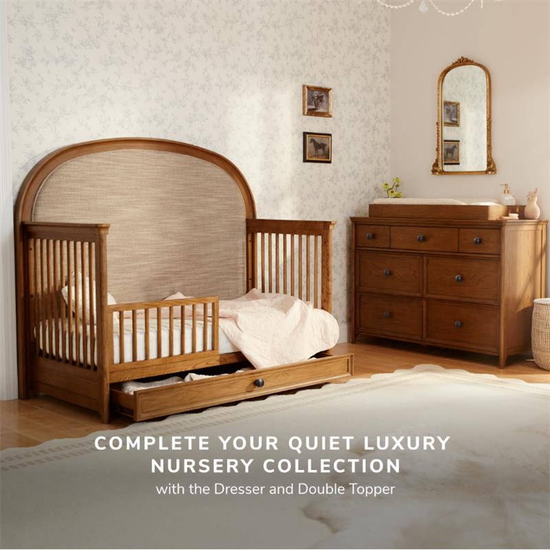 Maxi Cosi Quiet Luxury 6-in-1 Convertible Crib with toddler bed, set in a nursery with wooden furniture and patterned wallpaper.