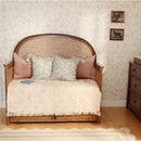 Maxi Cosi Quiet Luxury 6-in-1 Convertible Crib designed as a toddler bed, featuring soft pillows and decorative throw.