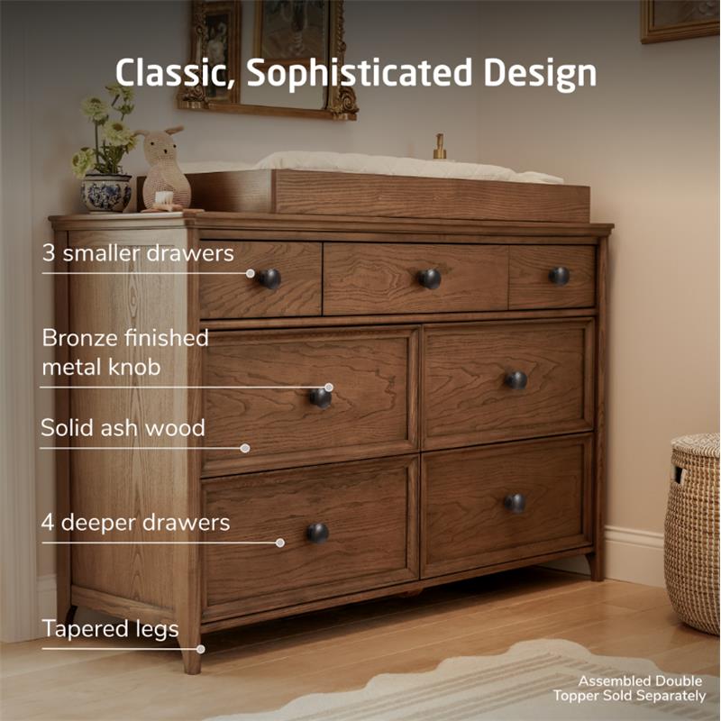 Maxi Cosi Quiet Luxury 7-Drawer Dresser made of solid ash wood, featuring three smaller and four deeper drawers with bronze knobs and tapered legs.