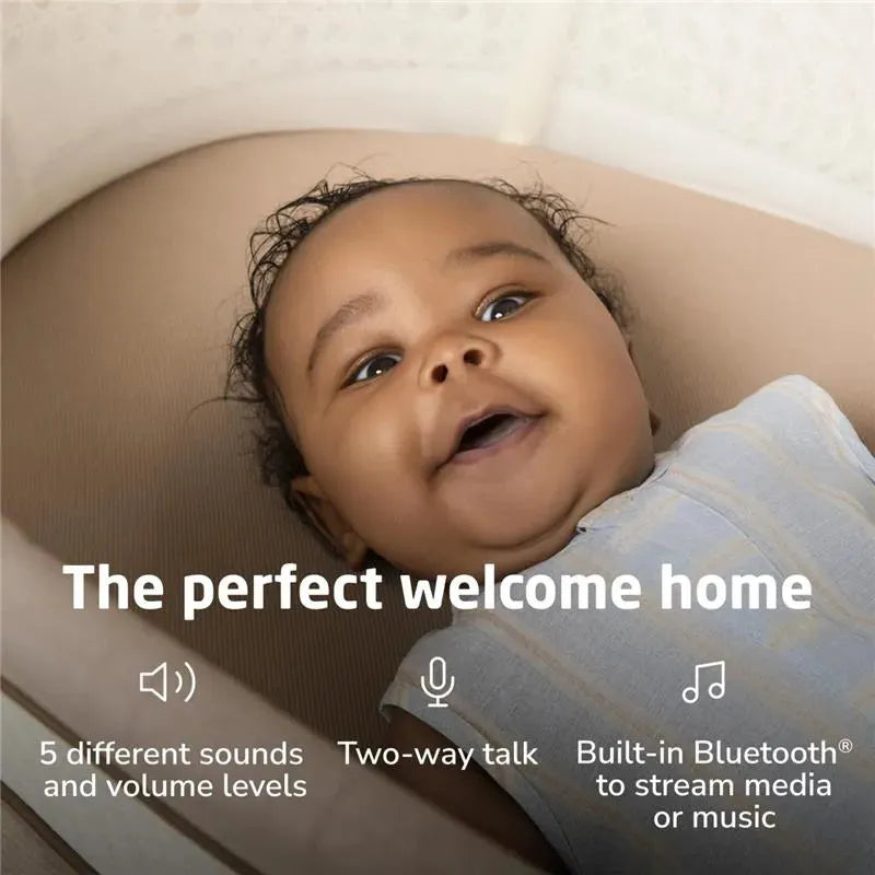 Smart bassinet with a smiling baby, showcasing features like Bluetooth, sounds, and two-way talk.
