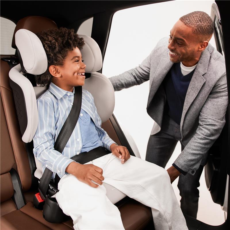 Maxi-Cosi Tanza Folding Belt-Positioning Booster Car Seat in Sea Drift, with a smiling child securely buckled in, and an adult nearby.