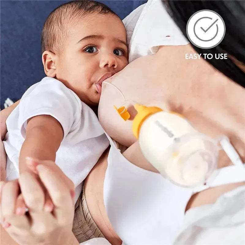 Infant breastfeeding from a mother using the Medela Supplemental Nursing System, showcasing a feeding tube attached to the breast.