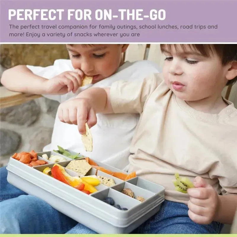 Grey Melii snack container with 12 compartments, filled with assorted snacks, held by two children enjoying a snack time.