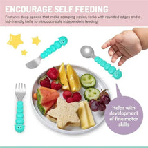 Toddler feeding spoon, fork, and knife set in teal, featuring bear and shark designs, alongside a plate of fruits and snacks.