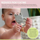 Baby holding a gray silicone dog-shaped teether with textured surfaces for easier gripping and sensory exploration.