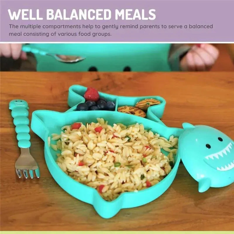 Divided silicone suction plate in shark shape, featuring compartments with pasta, berries, and cookies, promoting balanced meals.