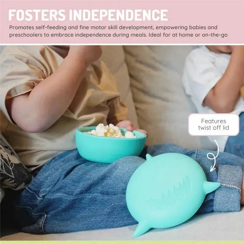 Silicone shark bowl with lid and utensils for self-feeding, promoting independence in young children during meals.