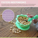 Silicone suction bowl in dino green with cereal and a child’s hand holding a fun, caterpillar-shaped spoon.