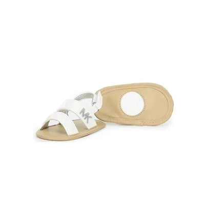 White patent baby sandals by Michael Kors with crisscross straps and an MK logo.