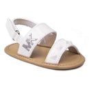 White patent baby sandals by Michael Kors featuring a closed toe design, adjustable strap, and silver MK logo.