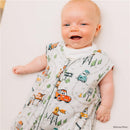 Baby smiling while wearing a Milk Snob Disney and Pixar Cars sleep bag, featuring colorful car and road patterns.