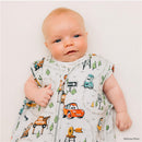 Baby wearing a Milk Snob Disney and Pixar Cars sleep bag with colorful character designs, smiling and giving a thumbs-up.