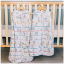 Milk Snob Disney Pixar Toy Story baby sleep bags, featuring colorful cartoon characters, hanging in front of a crib.