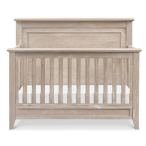 Rustic 4-in-1 convertible crib in sandbar finish, featuring a curved top and slatted front for safety.