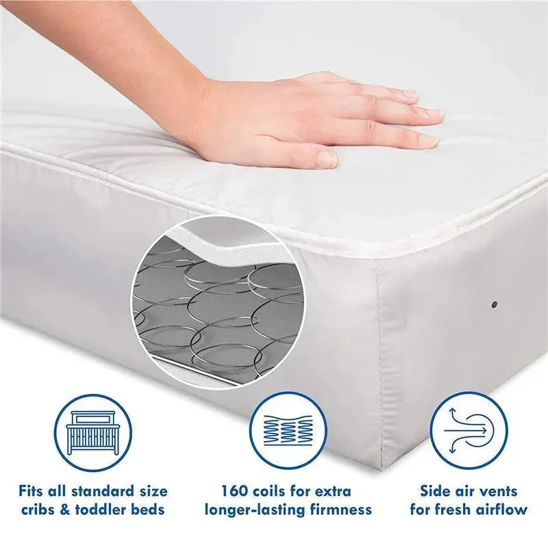 Deluxe coil crib mattress with a hand resting on its surface, highlighting 160 coils, side air vents, and compatibility with standard cribs.