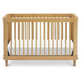 3-in-1 convertible crib in honey finish, featuring wooden slats, round corners, and a white mattress inside.