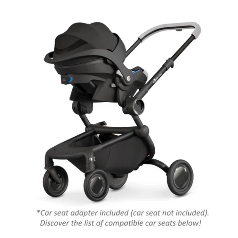 Single stroller displaying a sleek white frame and black car seat adapter, featuring a modern design and maneuverable wheels.