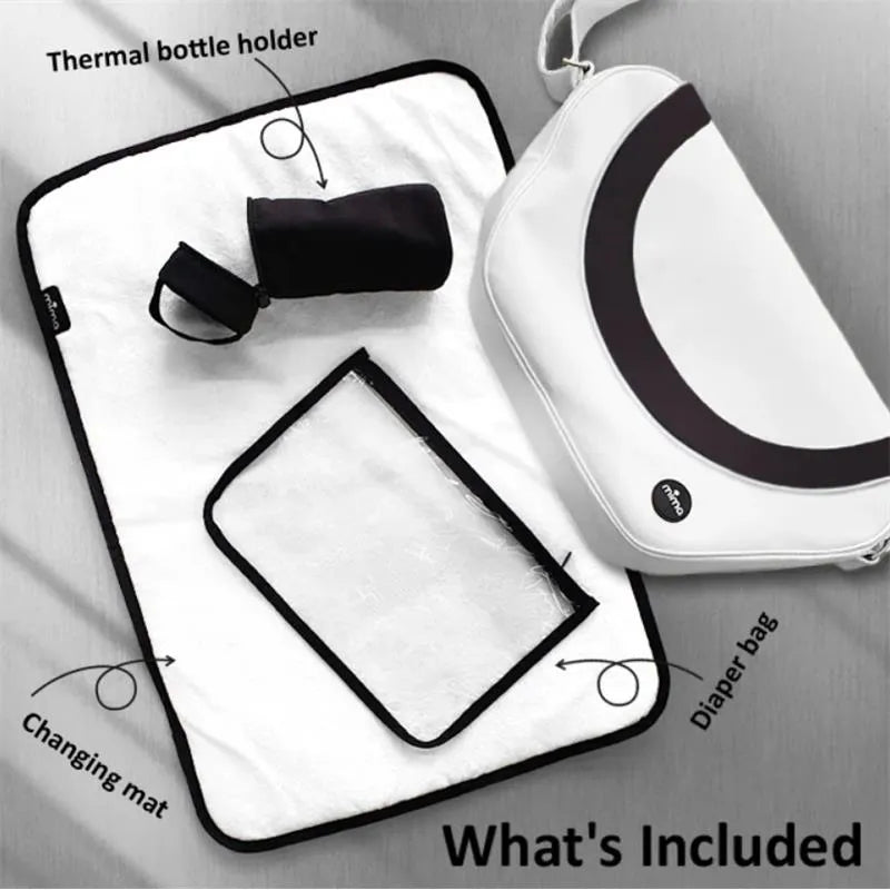 Trendy black Mima diaper bag with included changing mat and thermal bottle holder, displayed on a light background.