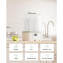 Momcozy 8-in-1 Baby Bottle Steam Sterilizer on a kitchen counter, with a digital display and icons for various functions.