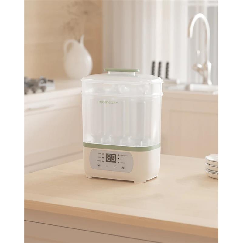 Momcozy 8-in-1 Baby Bottle Steam Sterilizer on a kitchen countertop, featuring a digital display and a transparent container.