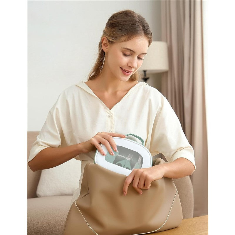 A woman inserts the Momcozy All-in-1 Core Baby Kit into a large beige handbag, smiling while handling the product.