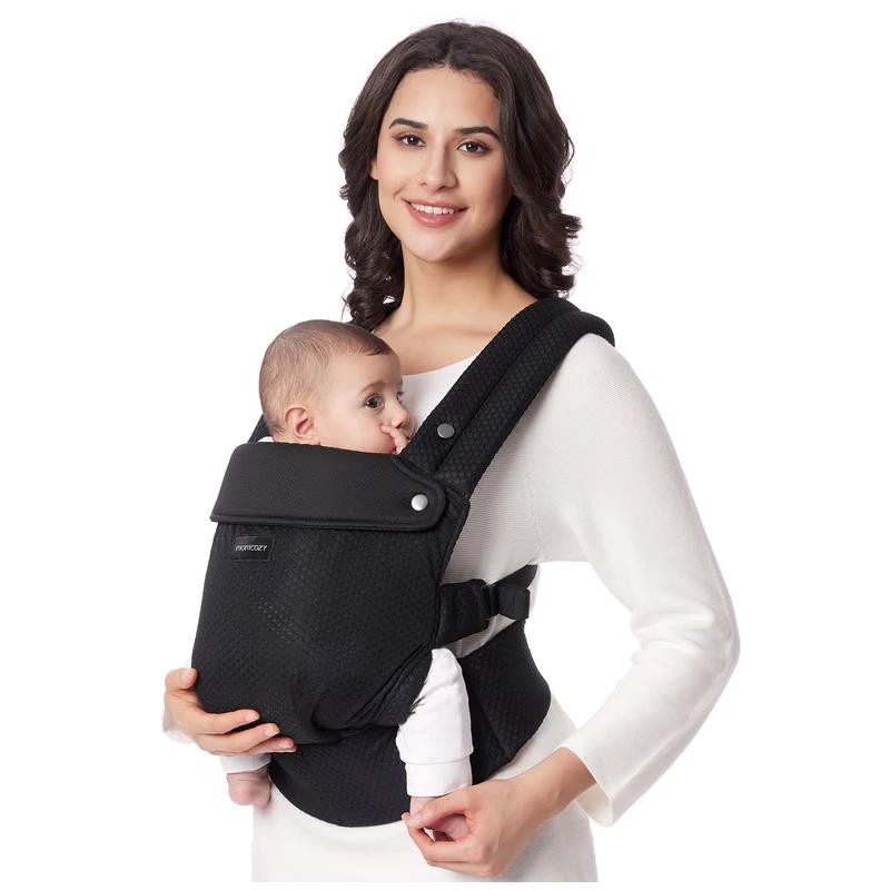 Mom holding a baby in a black mesh baby carrier, showcasing its ergonomic design and secure fit.