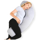 A pregnant woman relaxes while using a grey J-shaped maternity body pillow for support.