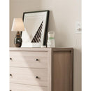 Portable Bottle Warmer MW03 by Momcozy on a dresser, next to a lamp and framed artwork, plugged into the wall.