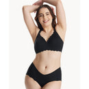 Seamless black floral push-up nursing bra worn by a smiling model with arms raised, showcasing comfort and style.